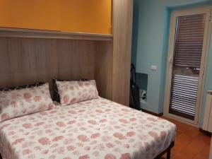 a bedroom with a bed with a floral comforter at domum solis in Marina di Cerveteri
