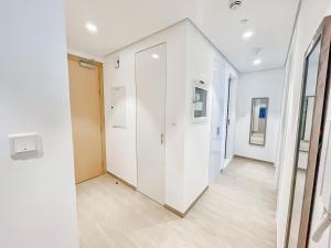 an empty hallway with white walls and wood floors at Luxury 2 Bedroom in the Nook 1 next to Metro Energy in Dubai
