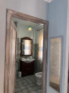 a bathroom with a sink and a toilet and a mirror at Villa Madau in Pula
