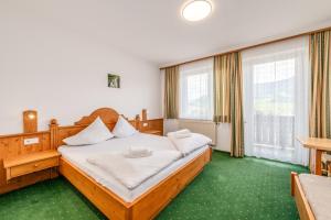 una camera con letto in legno e moquette verde di s'Wirtshaus by Alpine Genusswelten a Gröbming