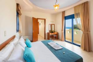 una camera da letto con un grande letto bianco con cuscini blu di Villa Clive by Villa Plus a Líndos Altre 16 foto