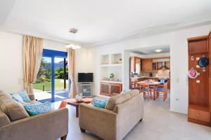 un soggiorno con due divani e una cucina di Villa Clive by Villa Plus a Líndos