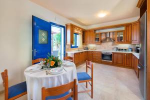 una cucina con tavolo e tovaglia bianca di Villa Clive by Villa Plus a Líndos