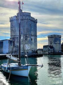a boat in the water in front of a castle at Chez la morena proche de La Rochelle in Lagord +11 photos