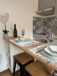 a table with plates and wine glasses on it at Chez la morena proche de La Rochelle in Lagord