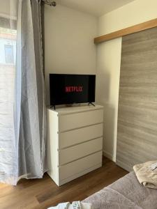 a tv on top of a dresser in a bedroom at Chez la morena proche de La Rochelle in Lagord