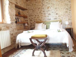 a bedroom with a bed with a stool on it at Casa de las Eras in Valdesimonte +65 photos
