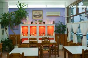 a dining room with tables and potted plants at Hotel Athina in Delphi