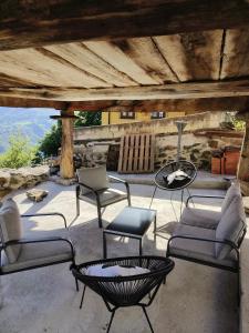 a patio with chairs and a table and a fire pit at Quirós Villa Tranquila de Salcedo 2 in La Villa