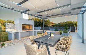 a patio with a table and chairs and a fireplace at Villa Tala in Mrljane