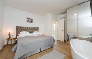 a white bedroom with a bed and a bath tub at Villa Tala in Mrljane