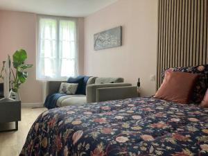 a bedroom with a bed and a couch at Alex Place's in Saint-Ouen-lʼAumône