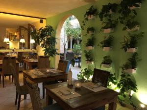 a restaurant with tables and plants on the wall at Villa Madau in Pula
