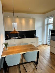 una cucina con un tavolo di legno e alcune sedie di Mountain Studio Mutters a Innsbruck
