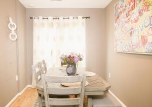 a dining room table with a vase of flowers on it at Charming 3bd Alexandria House, 11 miles to DC, Nice front view in Alexandria +43 photos