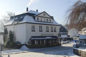 ein großes weißes Gebäude mit Schnee darüber in der Unterkunft Gasthof Susewind in Antfeld
