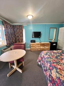 杰克逊维尔Budget Inn Jacksonville的一间酒店客房,配有一张床铺、一张桌子和一台电视