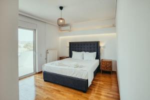 a bedroom with a bed and a large window at Grand Sea View Apartment 3' from Kavouri Beach in Athens