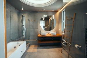 a bathroom with two sinks and a tub and a mirror at Grand Sea View Apartment 3' from Kavouri Beach in Athens +71 photos
