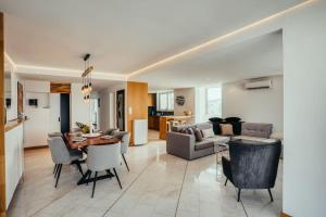 a living room and dining room with a table and chairs at Grand Sea View Apartment 3' from Kavouri Beach in Athens