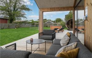 a living room with a couch and chairs on a patio at Nice Home In Ebeltoft With Sauna in Ebeltoft +28 photos