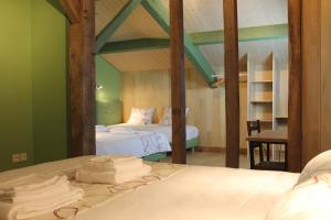 a bedroom with two beds with green walls at B&B La Ferme de la Patte d'Oie in Saint-Michel-Saint-Jaymes