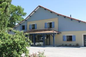 a large white house with blue windows at B&B La Ferme de la Patte d'Oie in Saint-Michel-Saint-Jaymes