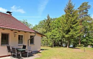 a house with a table and chairs in a yard at Ferienhaus Rheinsberg in Scharfenberg +12 photos