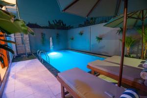 a swimming pool with a light in the middle at Villa Dua Warna Dencarik in Lovina