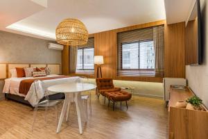 a bedroom with a bed and a table and chairs at TW Cyclinn Vila Olimpia in São Paulo