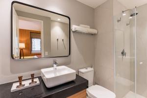 a bathroom with a sink and a mirror and a toilet at TW Cyclinn Vila Olimpia in São Paulo
