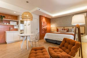 a bedroom with a bed and a table and a kitchen at TW Cyclinn Vila Olimpia in São Paulo