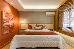 a bedroom with a large bed with orange walls at TW Cyclinn Vila Olimpia in São Paulo