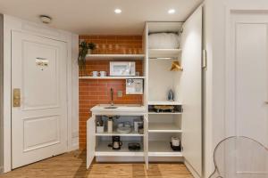 a small kitchen with a sink and a brick wall at TW Cyclinn Vila Olimpia in São Paulo