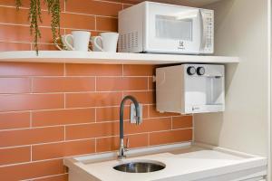 a kitchen with a sink and a microwave at TW Cyclinn Vila Olimpia in São Paulo