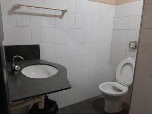a bathroom with a sink and a toilet at Hospedagem Familiar in Piúma