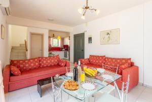a living room with a red couch and a glass table at Villa Georgia in Lourdata
