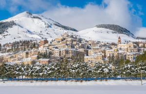 a town in the snow with a mountain at Come a casa in Rivisondoli