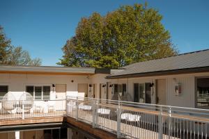 a building with a deck with white chairs on it at The Beach Motel in Southampton