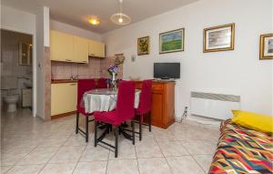 a kitchen and dining room with a table and red chairs at Lovely Apartment In Barbariga With Wifi in Barbariga