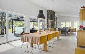 a dining room with a table and yellow chairs at Beautiful Home In Ebeltoft in Ebeltoft