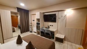 莱诺Hotel Lenotel的酒店客房 - 带一张床和一张带椅子的桌子