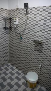 a bathroom with a toilet in a tiled wall at LakeSide Beach in Kigoma