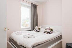 Un dormitorio con una cama con sábanas y almohadas blancas. en Borg Eteläranta, en Pori