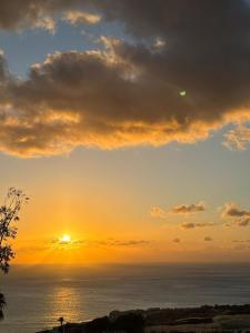 a sunset over the ocean with the sun in the sky at Casa Patio FincaEcoAmaro in Puerto de Santiago