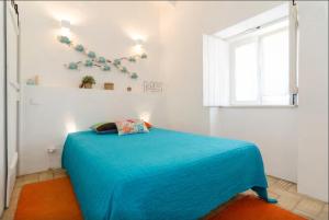 Un dormitorio con una cama azul y una ventana. en Casa da Nora, en Silves