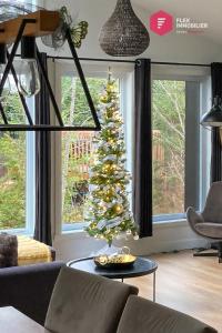 - un salon avec un arbre de Noël dans l'établissement Le Grand Pic de Portneuf - 65" TV, Sonos, SPA, Pool, Fireplace, Billiards, à Pont-Rouge