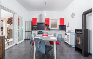 a kitchen with a table and chairs and red cabinets at Nice Home In Valbandon With Jacuzzi in Valbandon