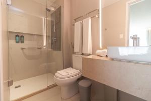 a bathroom with a shower and a toilet and a sink at Littoral Express in João Pessoa