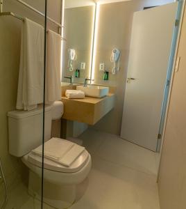 a bathroom with a toilet and a sink and a shower at Littoral Express in João Pessoa